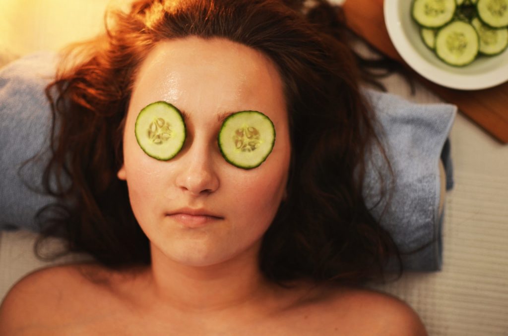 vrouw die aan het ontspannen is in een wellness thuis met komkommer op de ogen