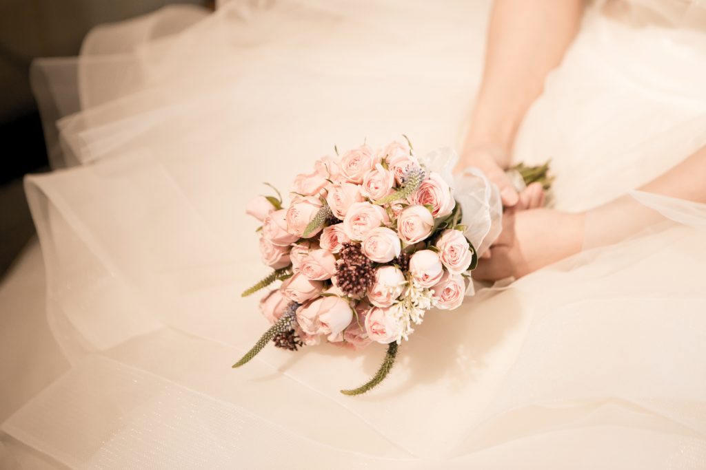 Bruid met een bruidsboeket vol met roze rozen. 